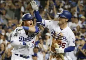  ?? MATT SLOCUM — THE ASSOCIATED PRESS ?? The Dodgers’ Justin Turner, left, celebrates his two-run home run with Cody Bellinger aduring the sixth inning of Game 1 Tuesday in Los Angeles.