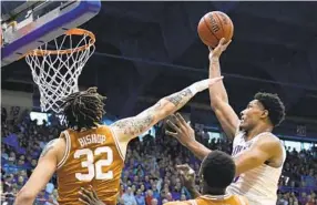  ?? REED HOFFMANN AP ?? Kansas forward David Mccormack, who had 22 points and 10 rebounds, shoots over the block attempt by Texas forward Christian Bishop during the first half Saturday.