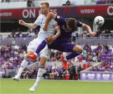  ?? TOMAS DINIZ SANTOS/AP ?? Fire forward Kacper Przybylko (left) tries to head the ball against Orlando City defender Rodrigo Schlegel.