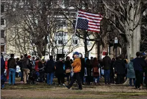  ?? AP/CAROLYN KASTER ?? A man walks with an American flag upside down during a protest Monday in Lafayette Square in front of the White House in Washington, to protest that President Donald Trump declared a national emergency along the southern border.