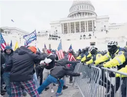  ?? JULIO CORTEZ/AP ?? Supporters of then-President Donald Trump rush forward in a bid to break through a police barrier during a riot Jan. 6 at the U.S. Capitol in Washington.