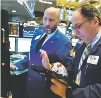  ?? RICHARD DREW/THE ASSOCIATED PRESS ?? Meric Greenbaum, left, and James Conti work Wednesday at the New York Stock Exchange, where the market took its biggest dive since September.