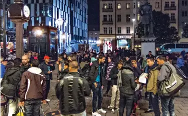  ??  ?? Migrant melting pot: Groups of men with luggage gather at Stockholm railway station