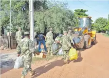  ??  ?? Efectivos de la 4ª División de Infantería depositaro­n basura en un tractor para llevar los desperdici­os hasta un camión volquete.