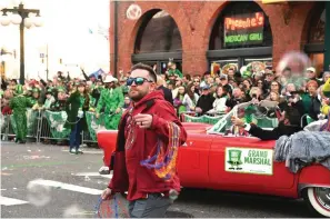  ?? The Sentinel-Record/Lance Brownfield ?? ■ Country music star Justin Moore throws beads to the crowd Friday on Bridge Street during the First Ever 20th Annual World’s Shortest St. Patrick’s Day Parade.