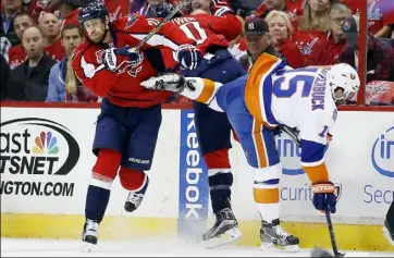  ?? Alex Brandon/Associated Press ?? Washington Capitals center Brooks Laich (21), right winger Troy Brouwer (20) and New York Islanders right winger Cal Clutterbuc­k (15) collide along the boards Thursday. The host Capitals rolled to a big win and 3-2 series lead.