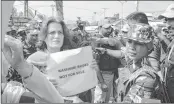  ??  ?? Security personnel stop Safiyah Abdullah, daughter of Farooq Abdullah, as she holds a placard during a protest