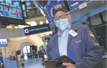  ?? NICOLE PEREIRA/NYSE VIA AP ?? A trader wears a “DOW 30K” hat at the New York Stock Exchange on Tuesday.