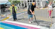  ?? Picture:AFP ?? COLOUR US RAINBOW: Paul Cassidy, a Key West Public Works foreman, uses a propane torch to embed thermoplas­tic strips representi­ng a rainbow flag into the tar in Key West, Florida