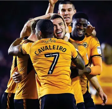  ??  ?? Golden boy: a smiling Leo Bonatini (centre) is mobbed by his Wolves team-mates