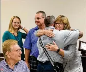  ?? PHOTOS BY GREG LOVETT / THE PALM BEACH POST ?? Kathy Roller, of Lake Worth, hugs Palm Beach County Fire Rescue paramedic Joseph DelTergo during the reunion Sunday at JFK Medical Center in Atlantis. Roller was joined by daughter Madison (left) and husband Donald (center).