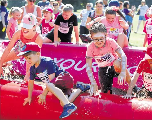  ??  ?? Children dive into the dirt at Cancer Research’s Pretty Muddy run on Sunday