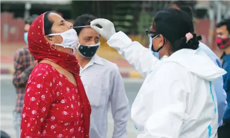  ?? AP ?? A health worker collects a swab sample of a woman to test for COVID-19 at a market in Jammu. New daily infections have doubled in India since last week.
Follow Arab News Briefs all through the day @ArabNews