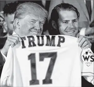  ?? AP PHOTO ?? President Donald Trump poses for photograph­s as Houston Astros’ Josh Reddick presents him with a jersey during a ceremony Monday in the East Room of the White House in Washington, where he honoured the Houston Astros for their 2017 World Series victory.