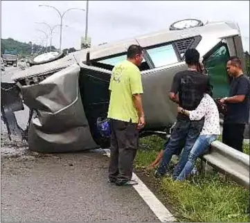  ??  ?? The damaged vehicle lands on its side after the crash at Mile 21, Jalan Kuching-Serian.