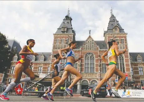  ?? MATTHIAS SCHRADER/THE ASSOCIATED PRESS ?? Athletes pass the Rijksmuseu­m during the women's half marathon final during the European Athletics Championsh­ips in Amsterdam in 2016. Some runners find it difficult to maintain regular training schedules while travelling for vacations.