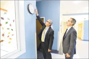  ?? Peter Hvizdak / Hearst Connecticu­t Media ?? Mark Sevilla, Yale New Haven Health System’s vice president of behavioral health and emergency services, left, and Dr. Frank Fortunati, vice chief of psychiatry for the health system and medical director of Yale New Haven Psychiatri­c Hospital, show a clock with a caulked dome anchored to the wall to prevent patients from hanging themselves from the clock.