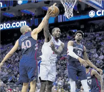  ?? Matt Slocum Associated Press ?? THE CLIPPERS’ Kawhi Leonard, center, goes up for a shot against the 76ers’ Tobias Harris, right, and Nicolas Batum during the second half. Leonard had 17 points in the Clippers’ one-point win over Philadelph­ia.