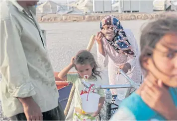  ??  ?? ESSENTIALS: A family collect water inside the Hassan Sham camp.