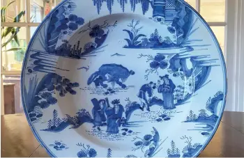  ?? ?? A Queen Anne English Delft charger decorated in the Chinese Transition­al taste