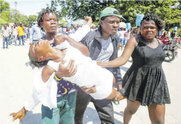  ??  ?? A family member of one of the victims of the ongoing violence is supported during clashes between the Presidenti­al Guard and demonstrat­ors carrying the coffins in Port-au-prince, Haiti, yesterday.