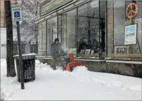  ?? PHOTOS BY NICHOLAS BUONANNO — NBUONANNO@TROYRECORD.COM ?? Ray Clement, owner of Clement Frame and Art store in downtown Troy, operates a snowblower on the sidewalk outside of his business Friday morning.
