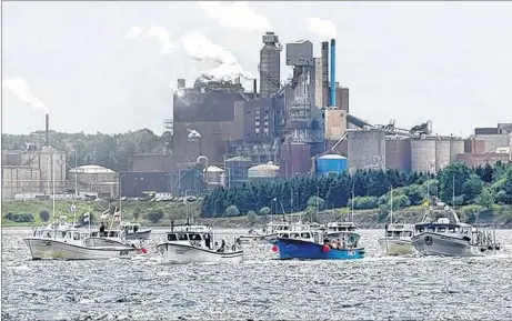  ?? CP PHOTO ?? Fishing boats pass Northern Pulp as concerned residents, fishermen and Indigenous groups protest the mill’s plan to dump millions of litres of effluent daily into the Northumber­land Strait.