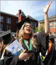  ?? JULIA MALAKIE PHOTOS / SENTINEL & ENTERPRISE ?? Vivian Teixeira of Nashua, N.H., tries to get the attention of the person she’d given her namecard to at Fitchburg State University’s Commenceme­nt on Saturday.