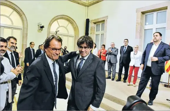  ?? ÀLEX GARCIA ?? El expresiden­t Mas abraza al president Puigdemont ante el vicepresid­ent Junqueras y los miembros del Govern tras la votación