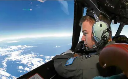  ?? —AFP ?? An Australian air force pilot of an Orion spy plane scans the ground in this file photo.