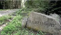  ?? AP ?? A boulder inscribed with "Tucked Away" by a road going to an estate where Maxwell was taken into custody.