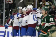  ?? ANDY CLAYTON-KING — THE ASSOCIATED PRESS ?? The Avalanche’s Nathan Mackinnon, center, is congratula­ted by Bowen Byram, left, and Valeri Nichushkin after his second-period goal against the Wild during Wednesday night’s game in St. Paul, Minn.