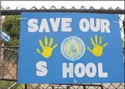  ?? JESSIE WARDARSKI/AP ?? Parents and students of the Rosary Catholic Academy hung sign showing they fear for their school’s future.