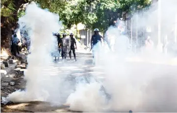  ??  ?? Police stand behind tear gas as they attempt to prevent an opposition gathering near the Sandaga market in Dakar. — AFP photo