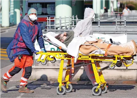  ?? Reuters ?? A patient is carried on a stretcher to a hospital in Rome as Italy’s daily coronaviru­s death toll shot up to 636 on Monday from 525 the day before.