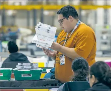  ?? Irfan Khan Los Angeles Times ?? AN ELECTIONS worker at a ballot processing center in the City of Industry. There has been a decades-long push in the state to provide voters with more options and protection­s, but that means a slower count.