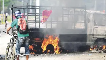  ?? EFE ?? Fuego. Un hombre pasa cerca de un vehículo incendiado, durante las protestas en Masaya, a unos 40 kilómetros al sureste de managua, ayer.