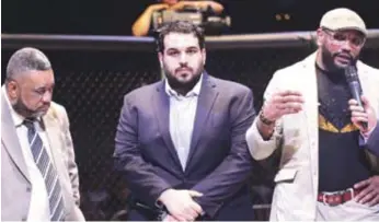  ??  ?? La estrella de la UFC, el cubano Yoel Romero saluda al público en un homenaje que se le rindió en la velada, le acompaña el promotor Rodolfo Dauhajre y el Comisionad­o Nacional de las Artes Marciales Mixtas, Yoel Adames.