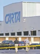  ?? STAFF PHOTO BY ERIN O. SMITH ?? Investigat­ive agents walk across a CARTA parking lot marked with crime scene tape Tuesday.