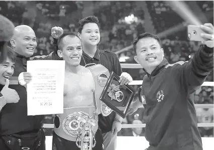  ?? / AP ?? ■ WORLD CHAMP. Ang head coach sa Ala Boxing Gym nga si Edito Villamor (tuo) nga nag-selfie uban sa bag-ong world champion nga si Milan Melindo (ikatulo), ug laing trainers nga sila si Michael Dominggo (wala), Edmond Villamor (ikaduha gikan sa tuo) ug...