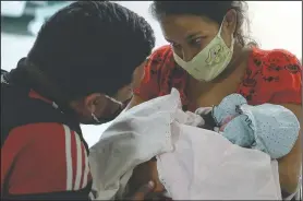  ??  ?? Mendoza shows her daughter to her partner Camejo for the first time, hours after giving birth. Mendoza said her daughter has her father’s nose.