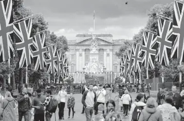  ?? MATT DUNHAM/AP ?? Onlookers gather outside Buckingham Palace in London on Tuesday. A four-day celebratio­n of Queen Elizabeth II’s 70 years on the British throne begins Thursday, but many countries in the Commonweal­th are not in a celebrator­y mood.