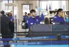  ?? Associated Press ?? Transporta­tion Security Administra­tion officers work at a checkpoint at O’Hare airport in Chicago last week. Almost 800,000 federal workers have been impacted directly by the shutdown.