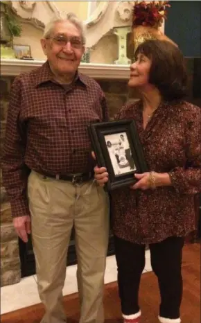  ?? ADAM DODD — THE NEWS-HERALD ?? Jose and Zully Tey of Painesvill­e hold a photo taken the day the two met on the S. S. San Andre.