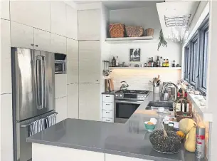  ?? DAVID ACOMBA ?? Kitchen storage was designed to be visible and invisible, with a wall of doors covering a pantry and cookware, and additional storage in three-foot spaces at ceiling height.