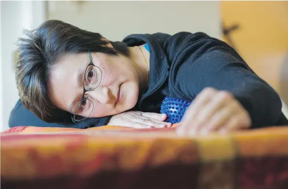  ?? GERRY KAHRMANN/PNG ?? Dr. Rassamee Ling, who is in recovery from breast cancer, uses a plastic massage ball covered in short, blunt spikes as part of her postoperat­ive rehabilita­tion, which focuses on using non-medicinal treatments to combat chronic pain.