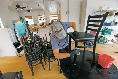  ?? PHOTOS BY LUIS SÁNCHEZ SATURNO/THE NEW MEXICAN ?? Ruth Lopez of Santa Fe cleans chairs at the new downtown eatery Pantry Rio on Tuesday. The restaurant is taking over the spot Restaurant L’Olivier vacated. The owners are hoping to put furloughed employees to work and cater to tourists.