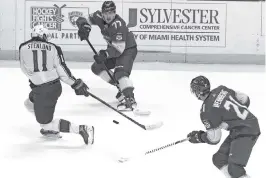  ?? CHARLES TRAINOR JR
ctrainor@miamiheral­d.com ?? The Panthers’ Alex Wennberg and Frank Vatrano (77) work the puck around Columbus’ Kevin Stenlund during Tuesday’s Florida win at the BB&T Center.