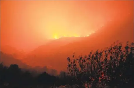  ?? Noah Berger Associated Press ?? THE KNP COMPLEX, sparked by lightning, burns along a hillside above the Kaweah River in Sequoia National Park on Tuesday.