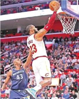  ?? — AFP photo ?? LeBron James (R)of the Cleveland Cavaliers gets to the basket past Anthony Tolliver of the Detroit Pistons during the first half at Little Caesars Arena on January 30, 2018 in Detroit, Michigan.